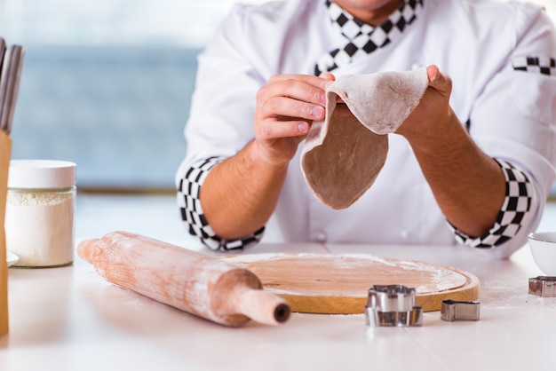 Jonge mensen kokende koekjes in keuken