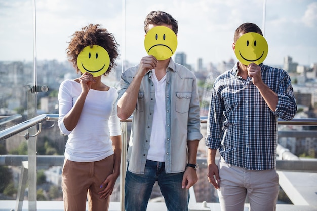 Foto jonge mensen met emoji's terwijl ze op het balkon van het stadsgebouw staan