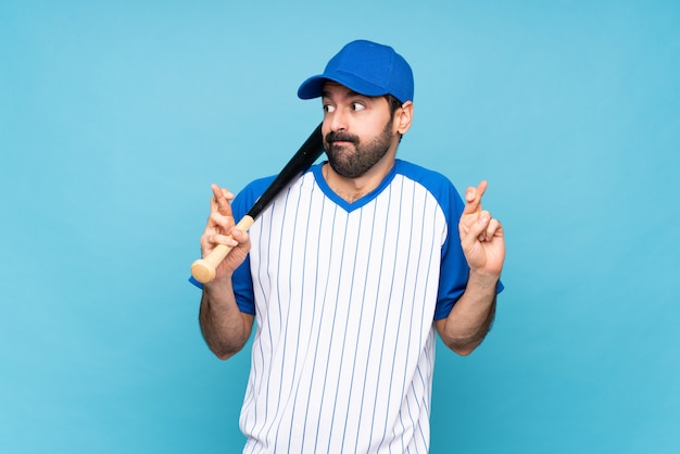 Jonge mensen speelhonkbal over geïsoleerd blauw met vingers die en het beste kruisen wensen