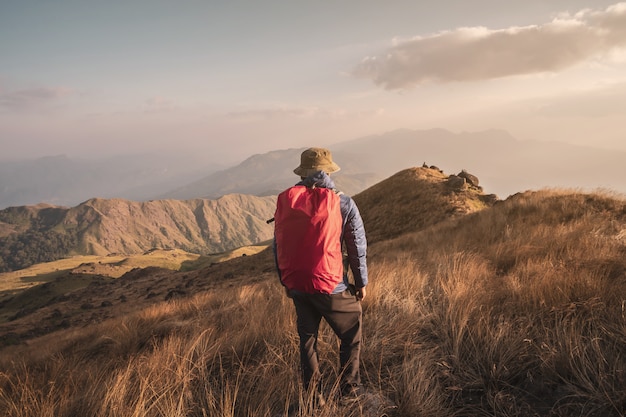 Jonge mensenreiziger met rugzaktrekking op berg, de levensstijlconcept van de Avonturenreis