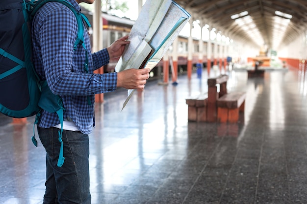 Foto jonge mensentoerist met rugzak bij het station in stad.