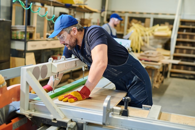 Jonge meubilairarbeider die houten plank bevestigt