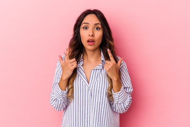 Jonge Mexicaanse die vrouw op roze muur wordt geïsoleerd die met geopende mond ondersteboven richt.