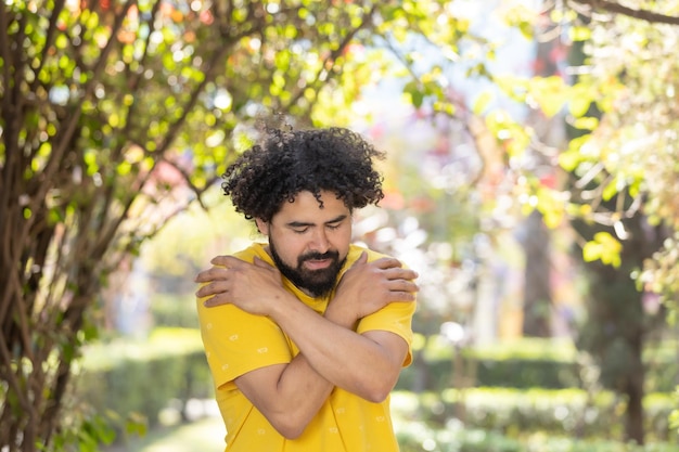 Jonge Mexicaanse man met baard en afro knuffelen zichzelf zelfliefde concept