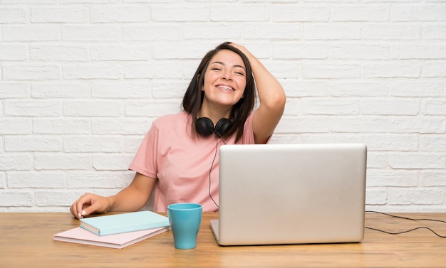 Jonge Mexicaanse vrouw met laptop het lachen