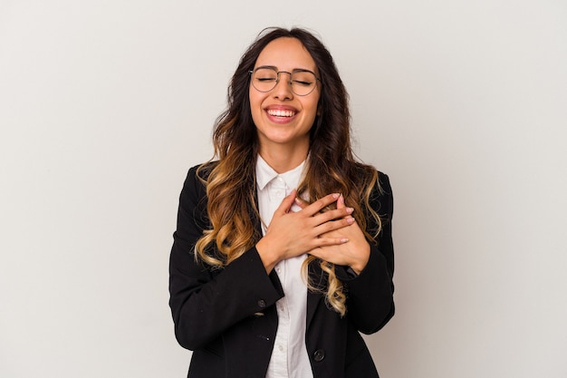Jonge Mexicaanse zakenvrouw geïsoleerd op een witte achtergrond lachen houden handen op het hart, concept van geluk.