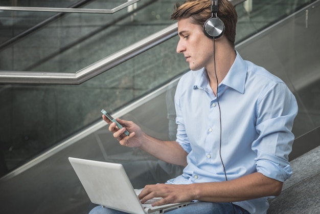 jonge model hansome blonde man hoofdtelefoon en een notebook