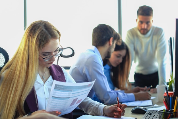 Jonge moderne collega's in nette vrijetijdskleding die samenwerken terwijl ze tijd doorbrengen in het creatieve kantoor