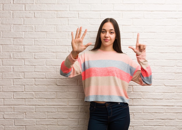 Jonge moderne vrouw die nummer zeven toont