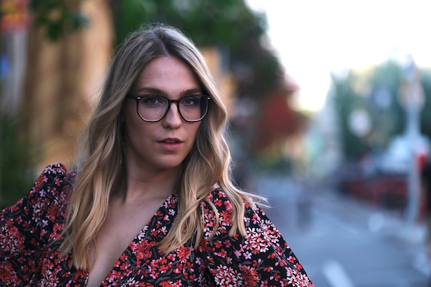 Jonge modevrouw die op zoek is terwijl ze voor de camera poseert op een straat in Barcelona