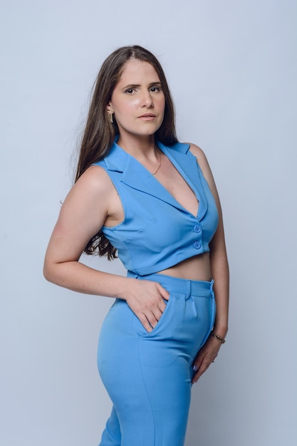 jonge modieuze Latijns-Amerikaanse vrouw in blauwe kleding in zakelijke stijl poseert naar de camera