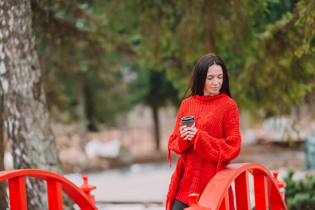 Jonge modieuze vrouw het drinken koffie om in een stadsstraat te gaan