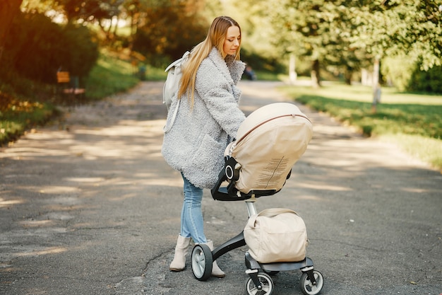 Jonge moeder die een wandelwagen duwt