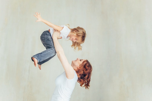 Jonge moeder die haar kind houdt. Gelukkige familie thuis. Jonge moeder spelen whith haar dochter.