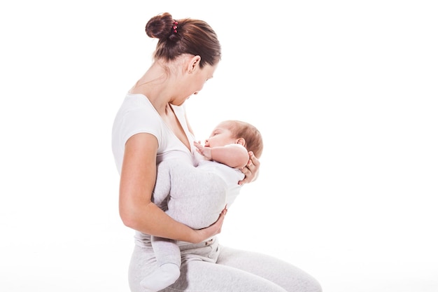 Jonge moeder die haar kind vasthoudt. moeder zogende baby geïsoleerd op wit