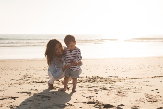 Jonge moeder die het strand verkent met haar baby