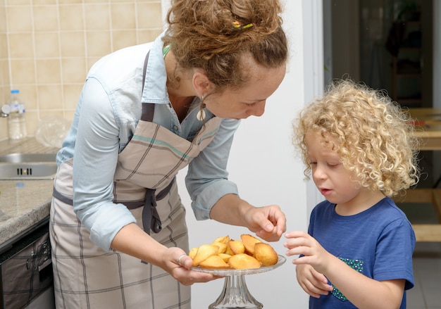 Jonge moeder die koekjes geeft aan haar kind