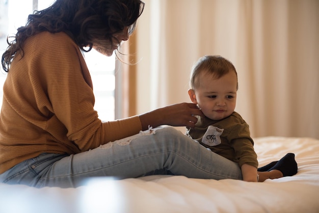 Jonge moeder die tijd doorbrengt met haar kleine baby