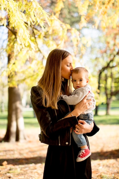 Jonge moeder en babyjongen in de herfstpark