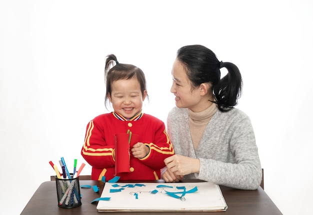 Jonge moeder en dochter spelen papier gesneden