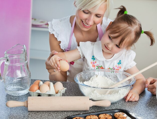 Jonge moeder en kind koekjes bakken