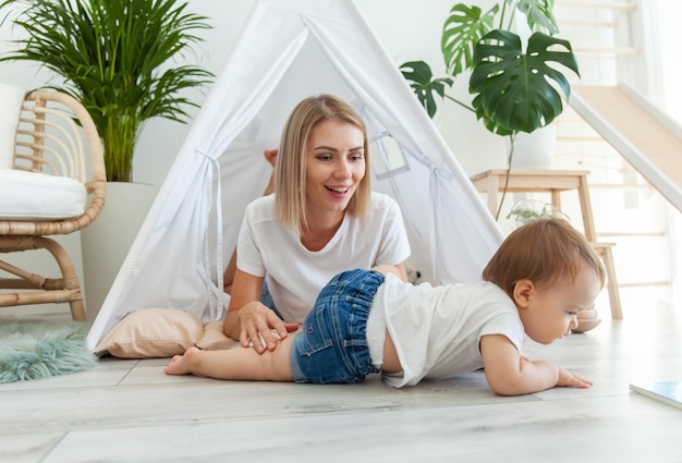 Foto jonge moeder en kleine dochter brengen tijd samen door in een wigwam thuis