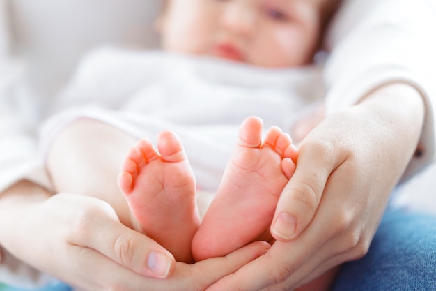 Jonge moeder en pasgeboren baby in witte slaapkamer