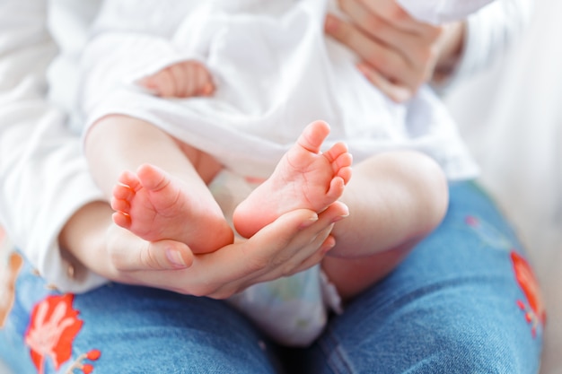 Jonge moeder en pasgeboren baby in witte slaapkamer