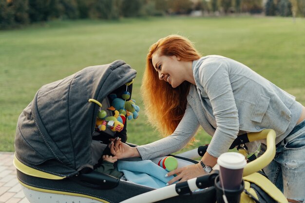 jonge moeder genieten van wandeling in park met baby