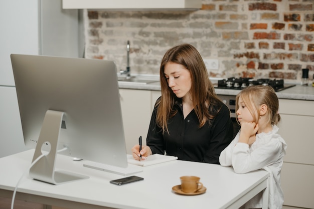 Jonge moeder helpt haar dochter met huiswerk