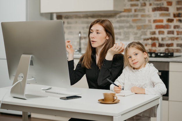 Jonge moeder helpt haar dochter met huiswerk