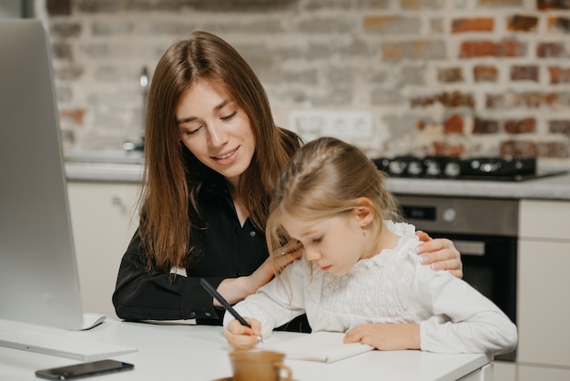 Jonge moeder helpt haar dochter met huiswerk