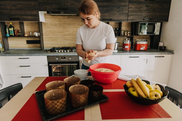 Jonge moeder kneedt het deeg voor het bakken van feestelijke paastaarten