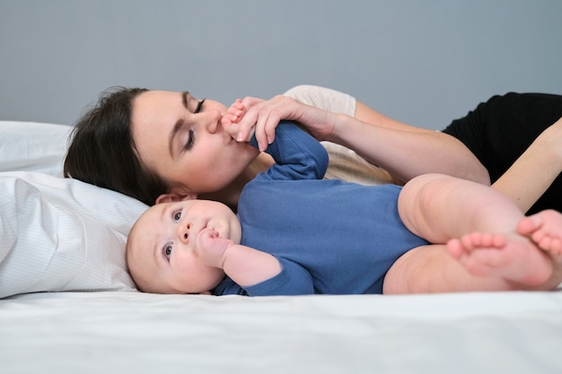 Jonge moeder kust liefdevol haar zoon peuter