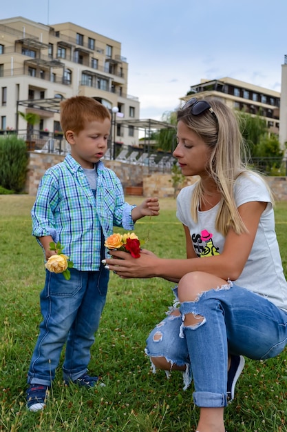 Jonge moeder met babyjongen op vakantie zomerdag in het park familie vakantie liefde en zorg