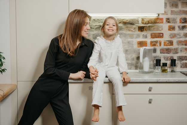 Jonge moeder met haar dochter in de keuken