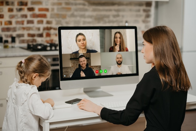 Jonge moeder met haar dochter tijdens online lessen