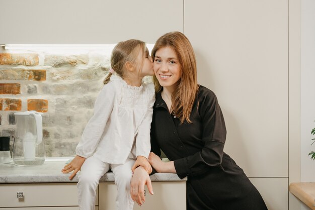 Jonge moeder met haar schattige dochter in de keuken