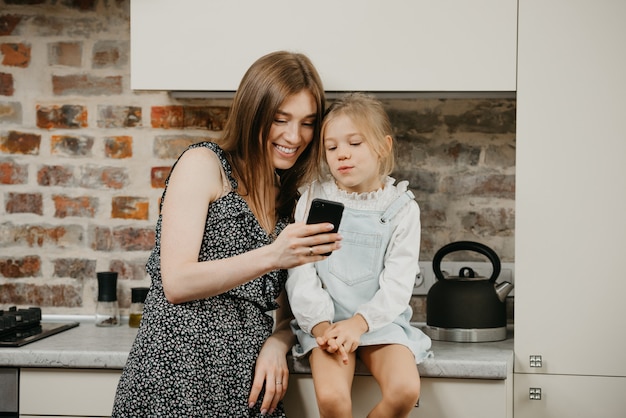 Jonge moeder met haar schattige dochter in de keuken