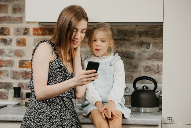 Jonge moeder met haar schattige dochter in de keuken