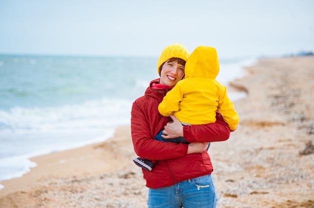 Jonge moeder met haar zoon aan de kust in de winter