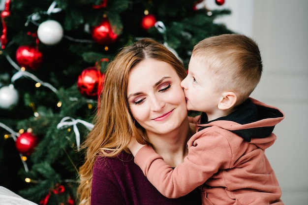 Jonge moeder met haar zoon die Kerstmis viert