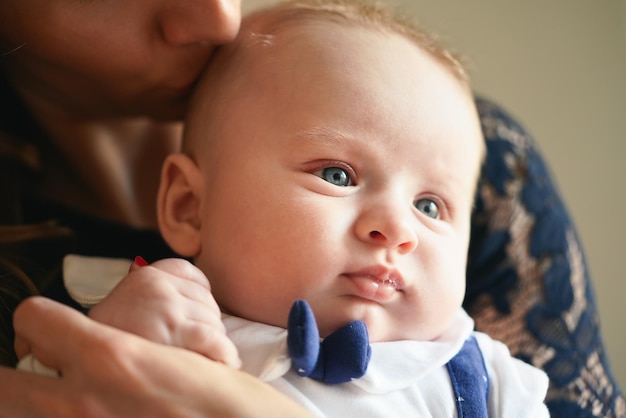 Jonge moeder met haar zoontje, detail op hoofden dicht bij elkaar, terwijl ze hem op hoofd kust