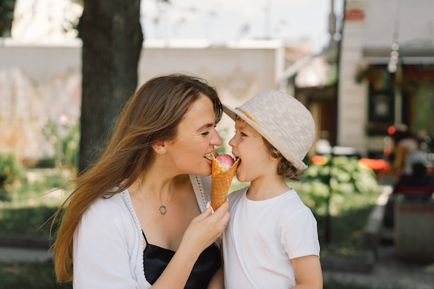 jonge moeder met kleine jongen buiten in de zomer die ijs eet, zomervoedsel en zomertijd