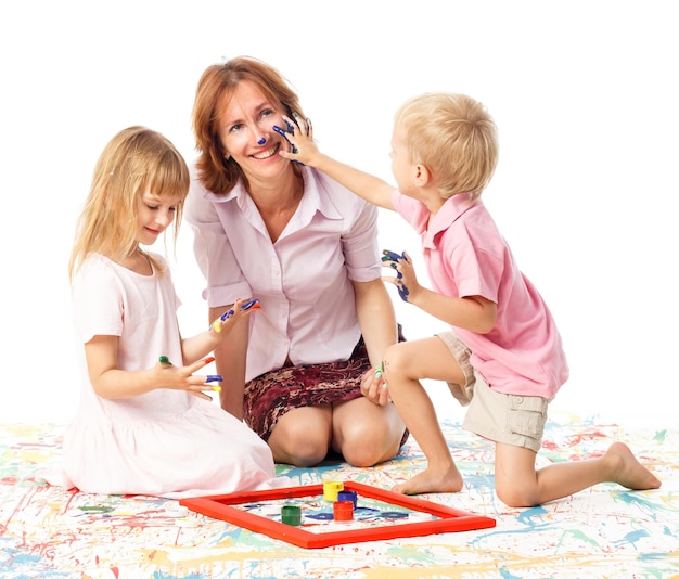 Jonge moeder met twee kinderen op witte gelukkige glimlachende familie binnen