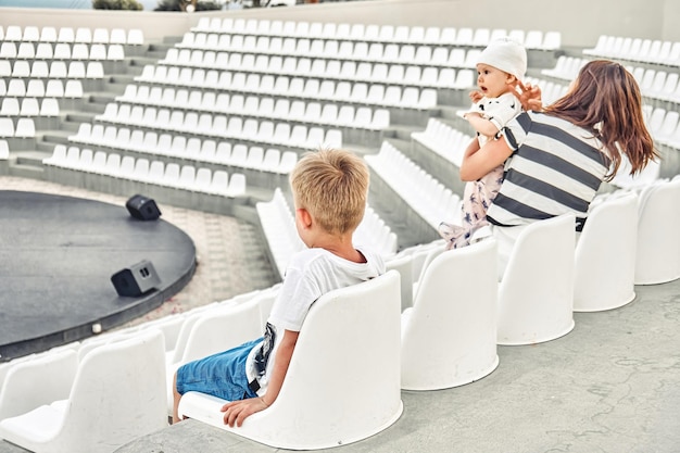 Jonge moeder met zonenzetels in leeg amfitheater