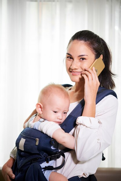 Jonge moeder praten over de telefoon