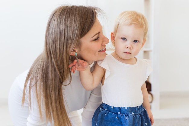 Jonge moeder spelen met haar babymeisje thuis