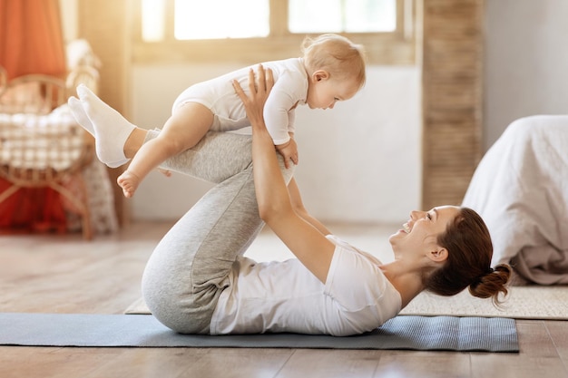 Jonge moeder traint samen met haar baby-peuter thuis