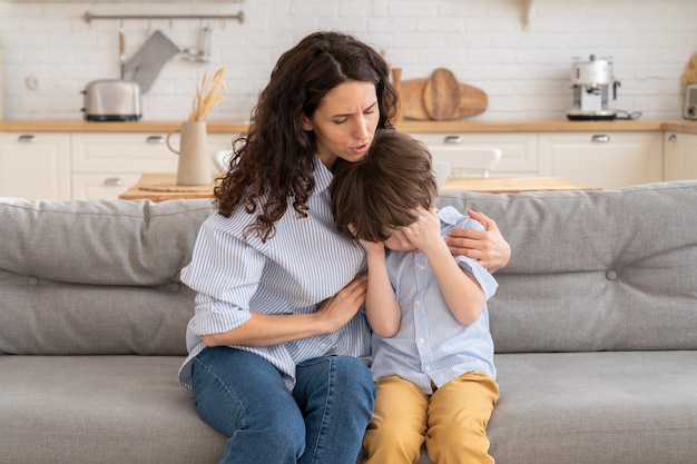 Jonge moeder troost huilende zoon